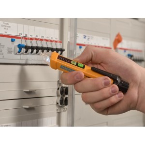Tester di tensione senza contatto giallo (12-1000V) in uso su una scatola dei fusibili.
