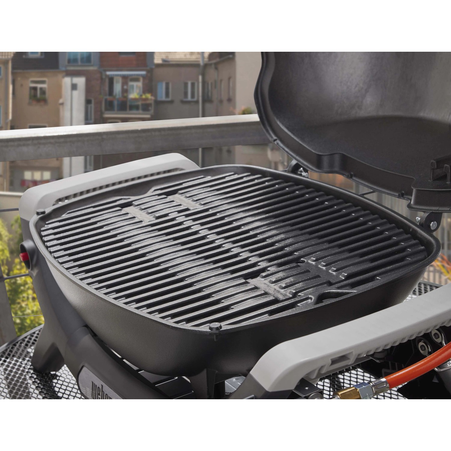 Barbecue a gas t.b.t. compatto per balcone o terrazza. Griglia e coperchio aperto visibili.