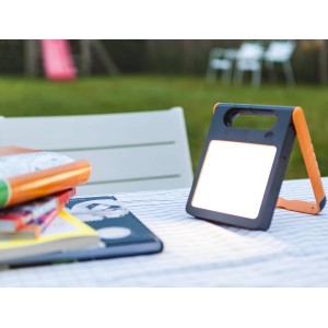 Lampada da tavolo: Luce solare LED quadrata con cornice arancione su un tavolo in giardino.