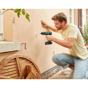 Uomo che fora un muro con il trapano avvitatore a percussione a batteria Bosch 18V EasyImpact 18V-40.