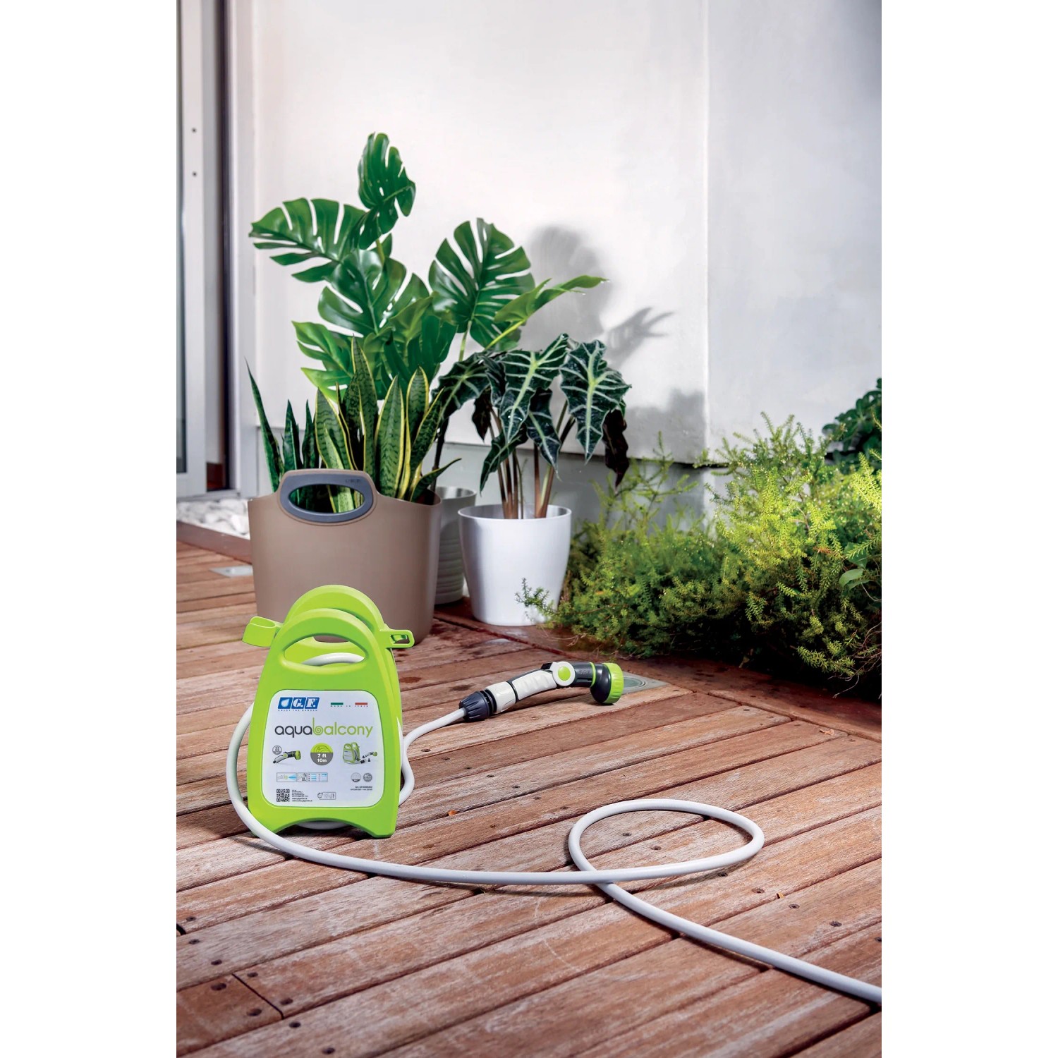 Unità di irrigazione t.b.t. portatile verde con tubo e testina a spruzzo su terrazza in legno.