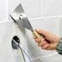 Mano che tiene spatola LUX rigida (100mm) per lisciare lo stucco su una parete.