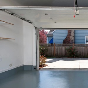 Garage aperta con pavimento grigio e vista sull'esterno.