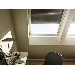 Tapparella solare Velux SSL CK02, grigio scuro, parzialmente aperta su una finestra per tetti in mansarda.