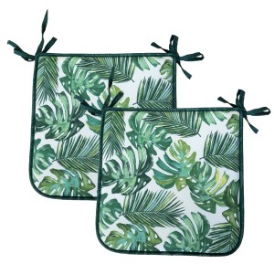 Due cuscini da esterno verdi con motivo a foglie tropicali.