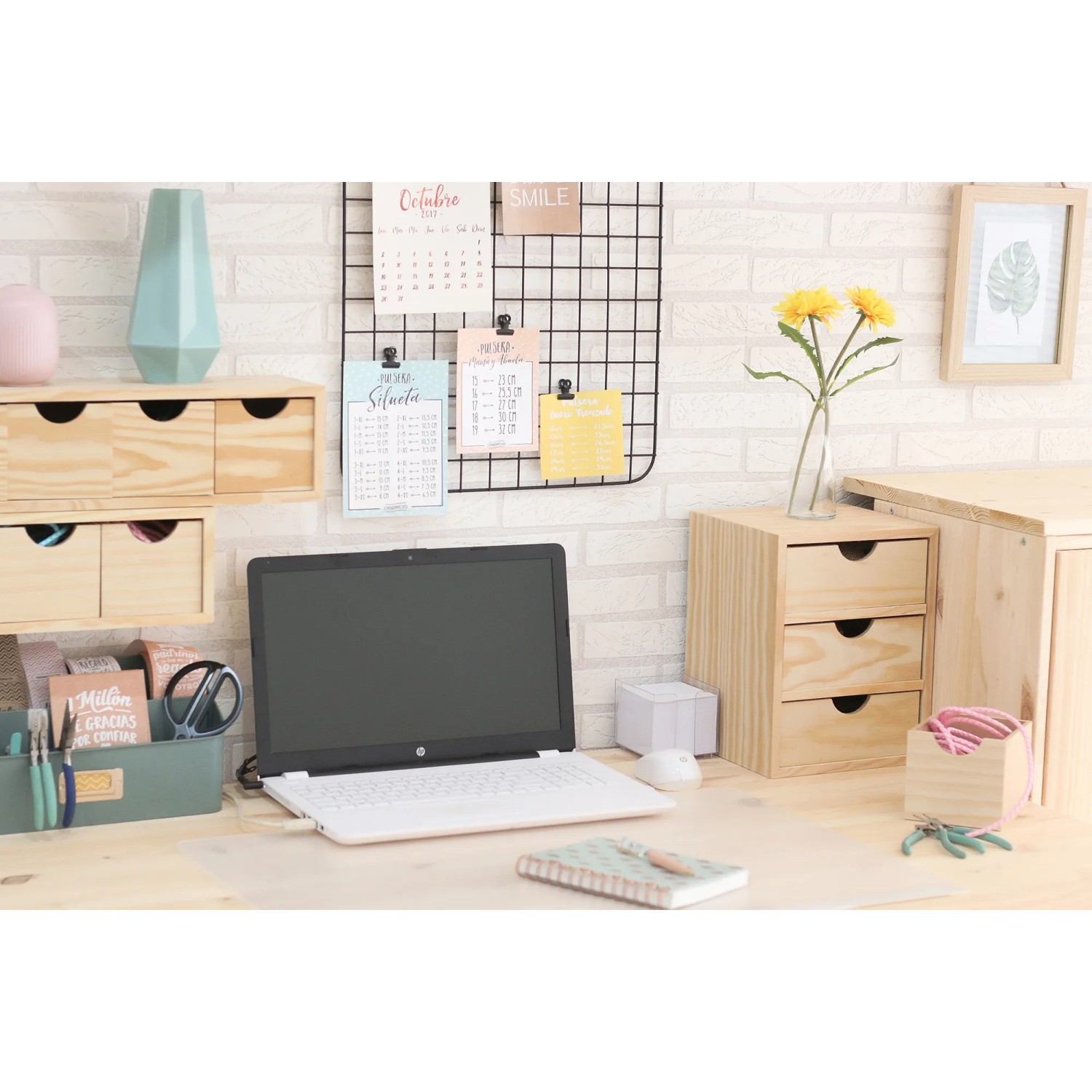 Scrivania con cassettiera t.b.t. in legno chiaro, laptop e decorazioni.