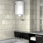Scaldabagno bianco (t.b.t.) in bagno con parete piastrellata.