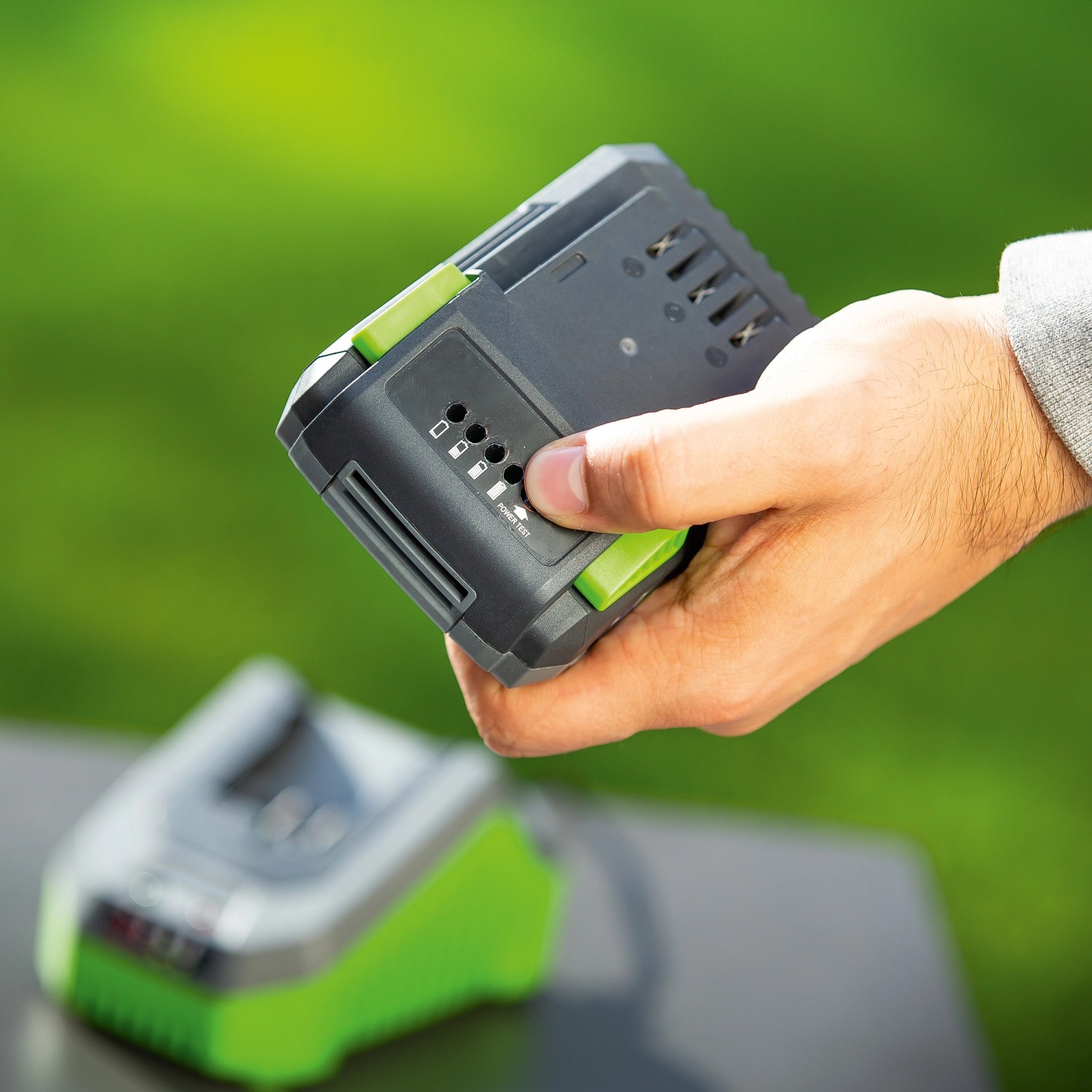 Batteria LUX 20V 2Ah in mano, indicatore di carica visibile. Batteria per elettroutensili 1 PowerSystem.