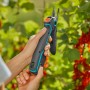 Forbici da giardino Gardena Assistcut in azione: cesoie a batteria che tagliano un ramo.