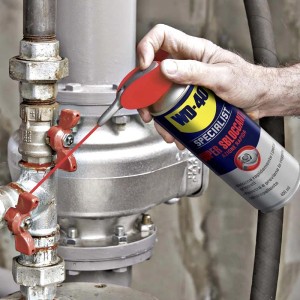 WD-40 Specialist Super Sbloccante in uso su un tubo metallico con valvole.
