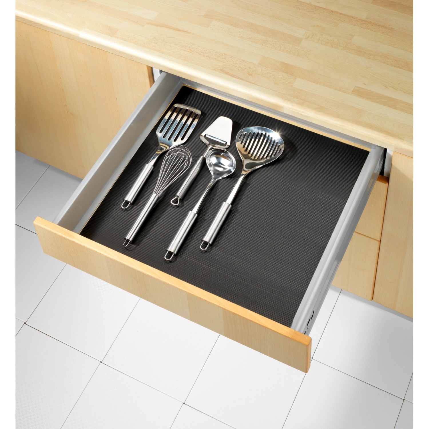 Tappetino antiscivolo nero Wenko (150x50 cm) in un cassetto con utensili da cucina.