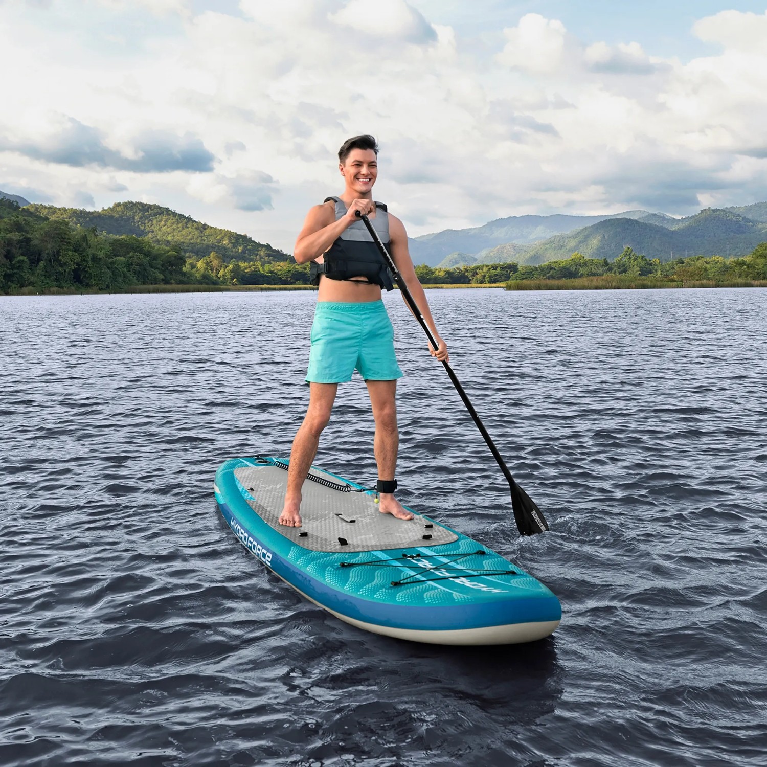 Uomo su tavola SUP Bestway Aqua Drifter con sedile e pagaia sull'acqua.