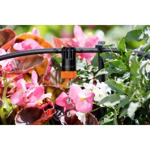 Primo piano di gocciolatore Claber Microirrigazione in uso. Irrigazione giardino.