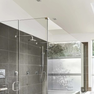 Doccia moderna con piastrelle grigie e divisorio in vetro. Design elegante del bagno.