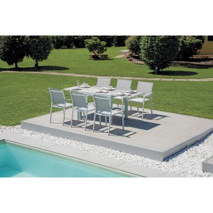 Set tavolo da giardino con tavolo e sedie su patio accanto alla piscina.