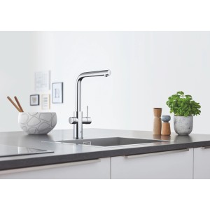 Kit base miscelatore monocomando Grohe Blue Home con bocca a L cromata su un piano cucina.