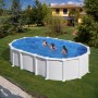 Piscina ovale Gre con pareti in acciaio Haiti, 610x375x132 cm, con sistema Omega e bagnanti in giardino.