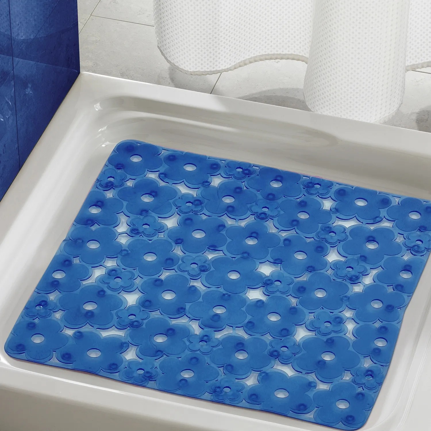Tappetino doccia blu con motivo floreale in una doccia. Tappetino antiscivolo per maggiore sicurezza.