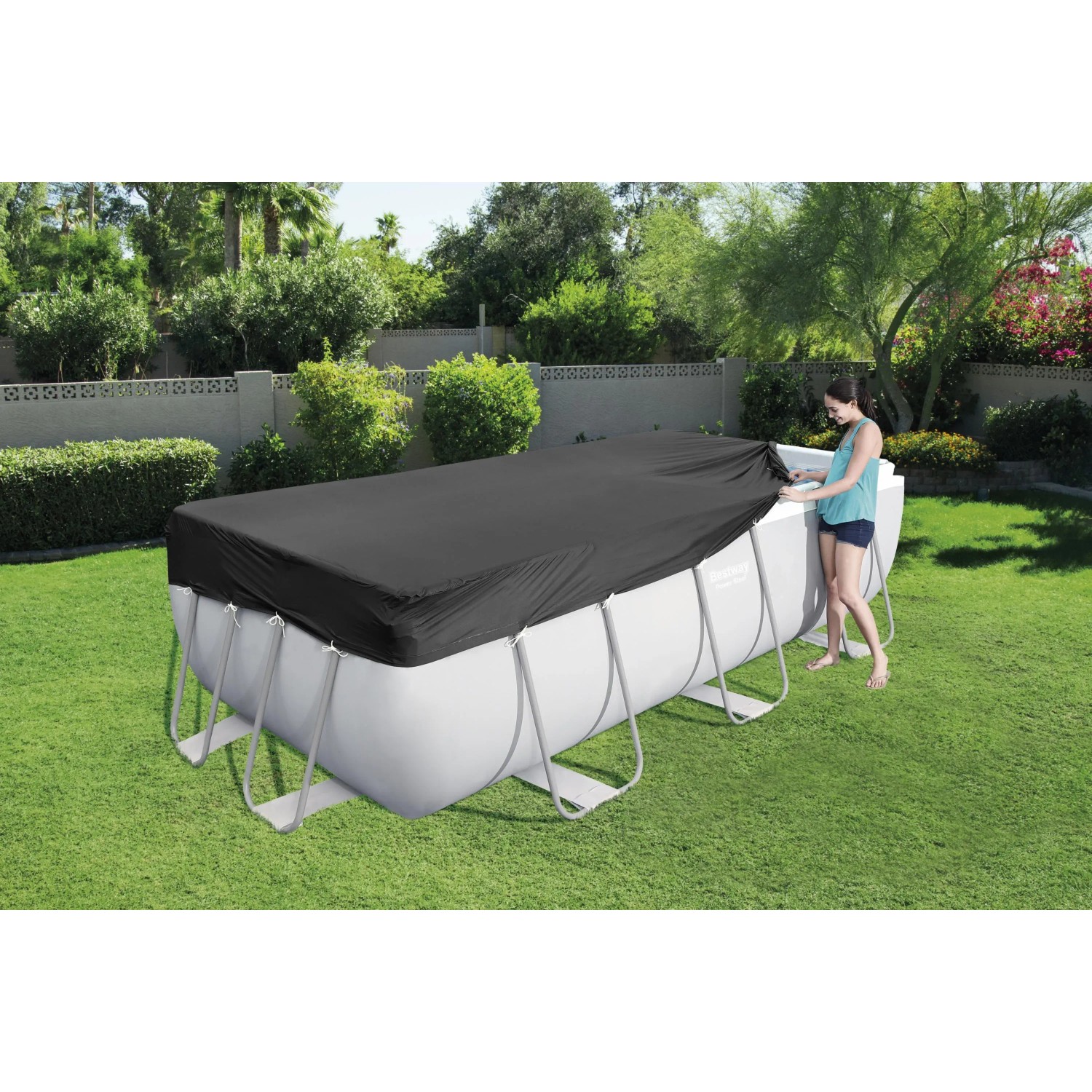 Copertura piscina: Copertura nera per piscina che protegge una piscina rettangolare in giardino.