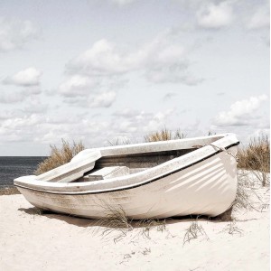 Quadri: Barca a remi bianca sulla spiaggia sotto un cielo nuvoloso.