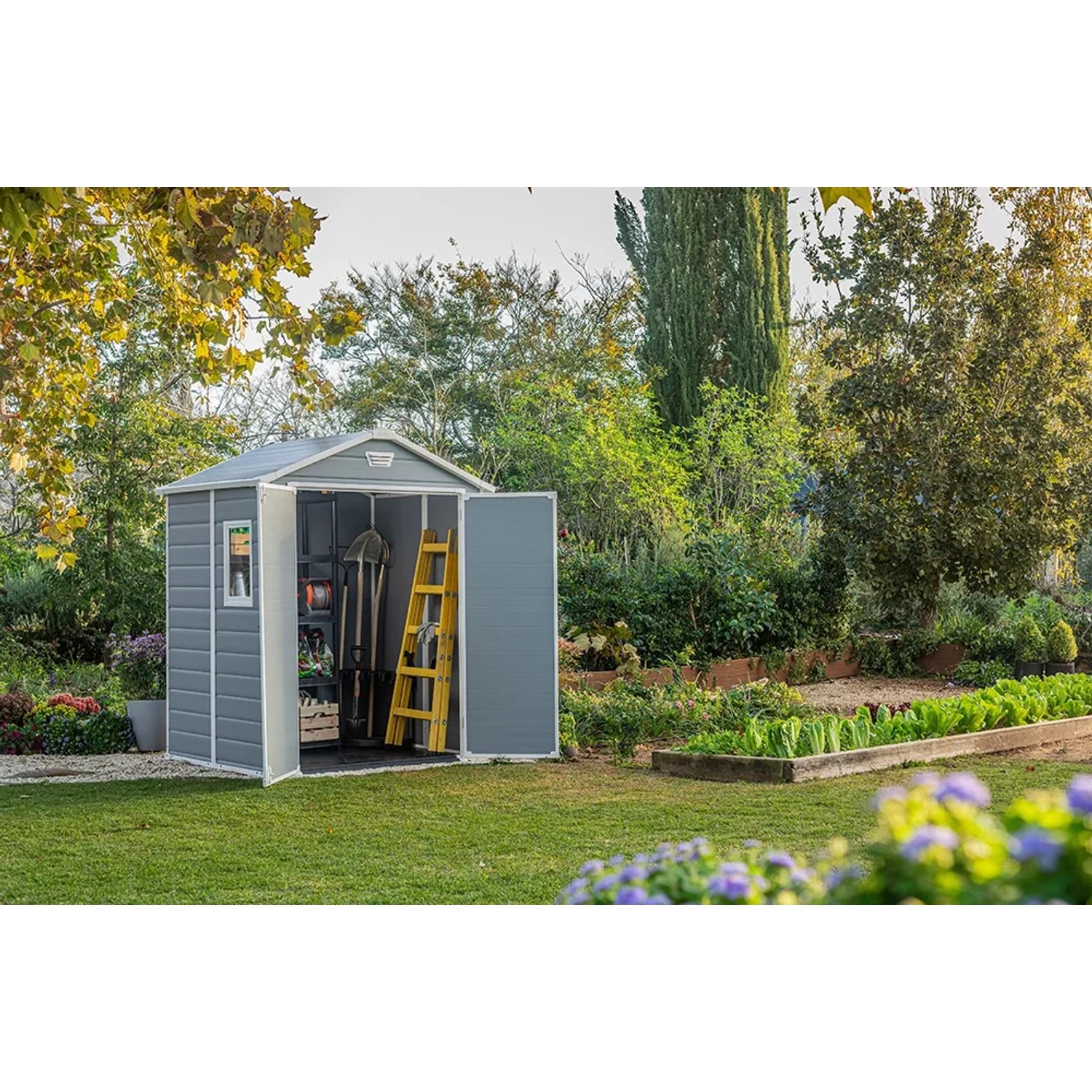 Casetta da giardino Keter Manor 65DD, grigio-bianca, con doppia porta aperta e attrezzi da giardino all'interno.