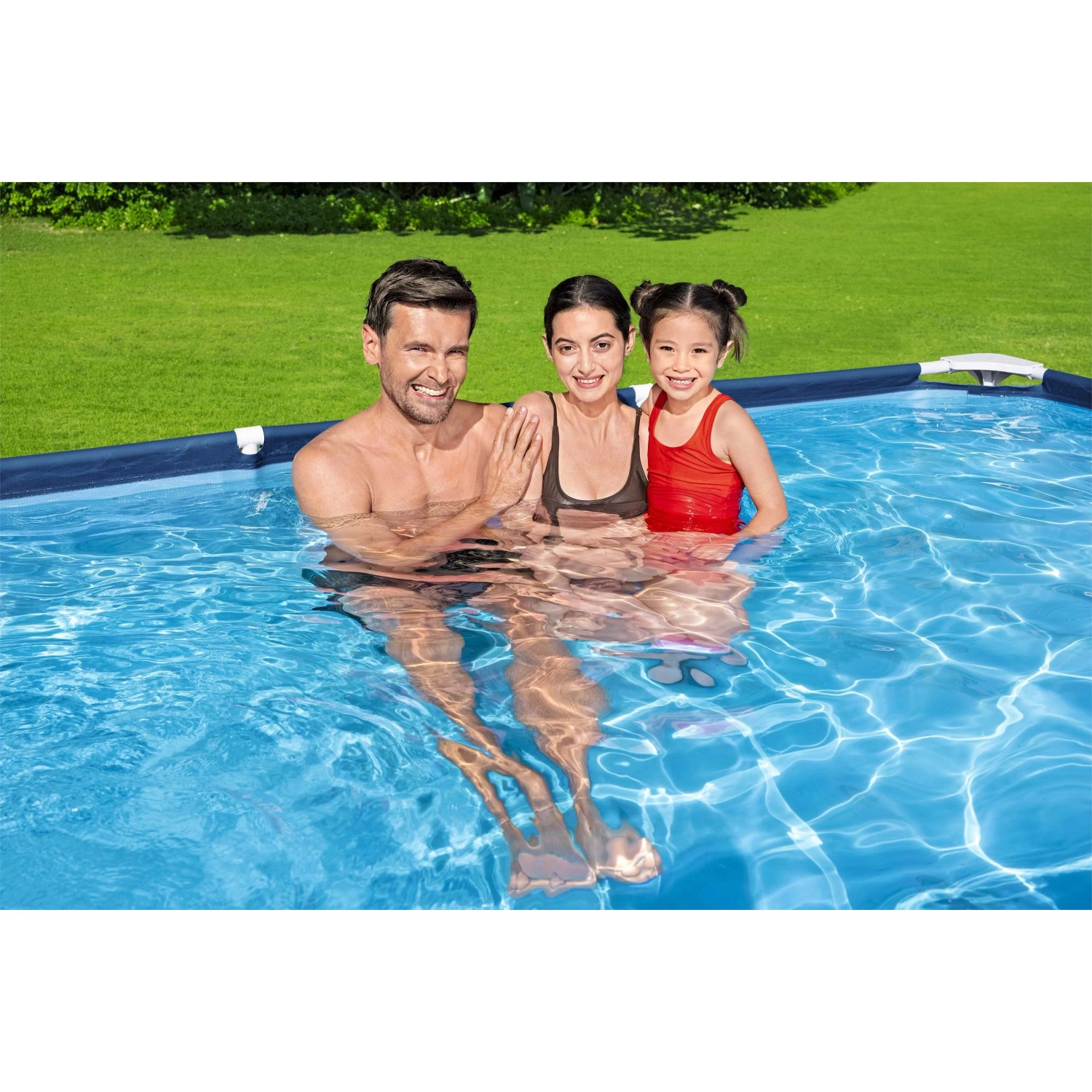 Famiglia si rilassa in una piscina t.b.t. blu. Piscina gonfiabile in giardino.