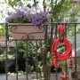 Tubo per irrigazione t.b.t. rosso su un balcone con fioriera.