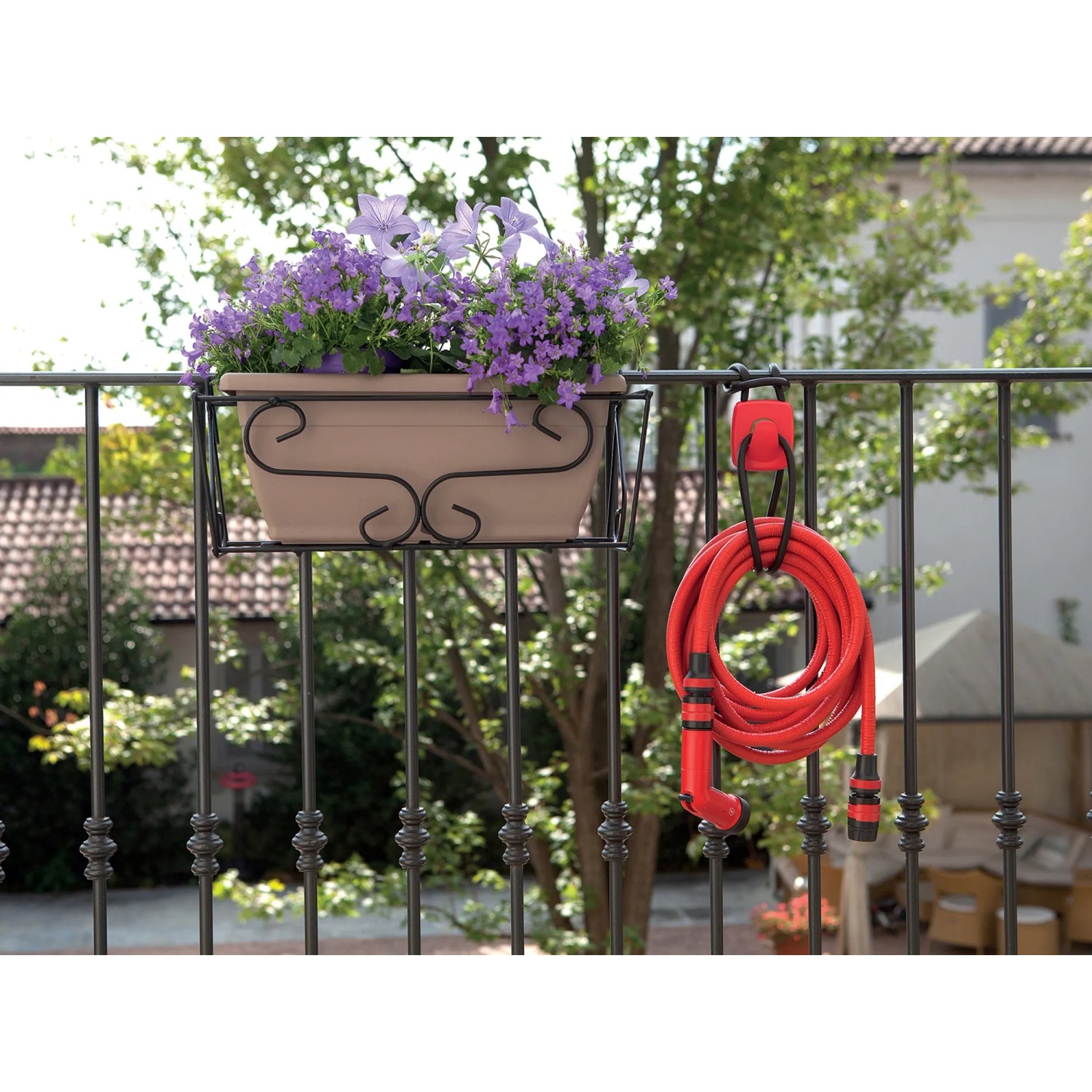 Tubo per irrigazione t.b.t. rosso su un balcone con fioriera.