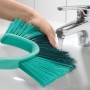 Leifheit Dusty spazzola manuale per pareti e soffitti sotto un rubinetto in un lavandino.