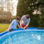 Padre e figlio riparano la piscina con nastro riparatore trasparente Tesa Ultra Power Under Water.