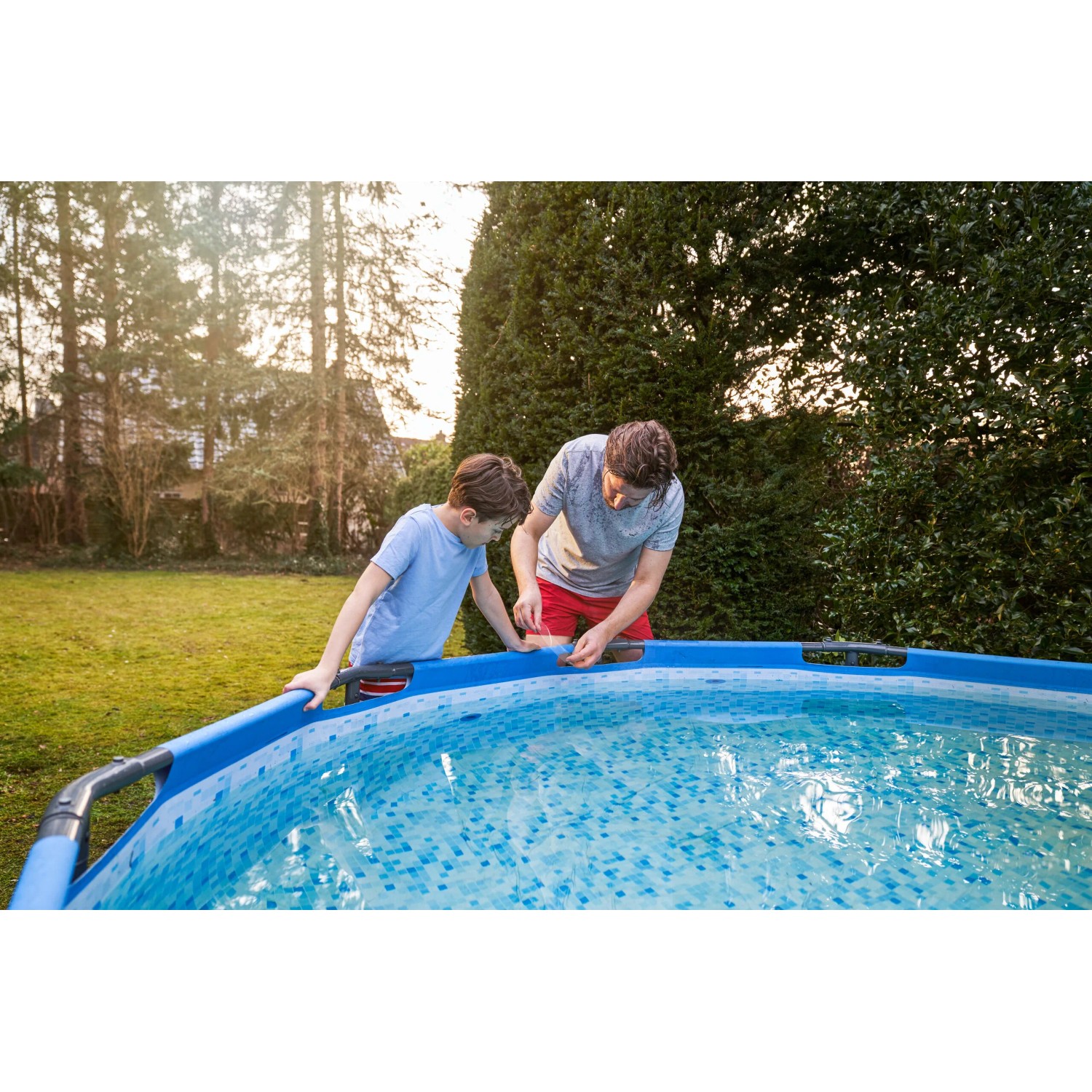 Padre e figlio riparano la piscina con nastro riparatore trasparente Tesa Ultra Power Under Water.