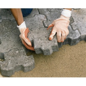 Mani con guanti da pavimentatore LUX taglia 10 che posano pavimentazione.