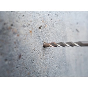 Punta per martello perforatore LUX Classic SDS-Plus che fora un muro di cemento. Punta per cemento con elica.