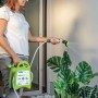 Donna che innaffia le piante con un tubo per irrigazione t.b.t.