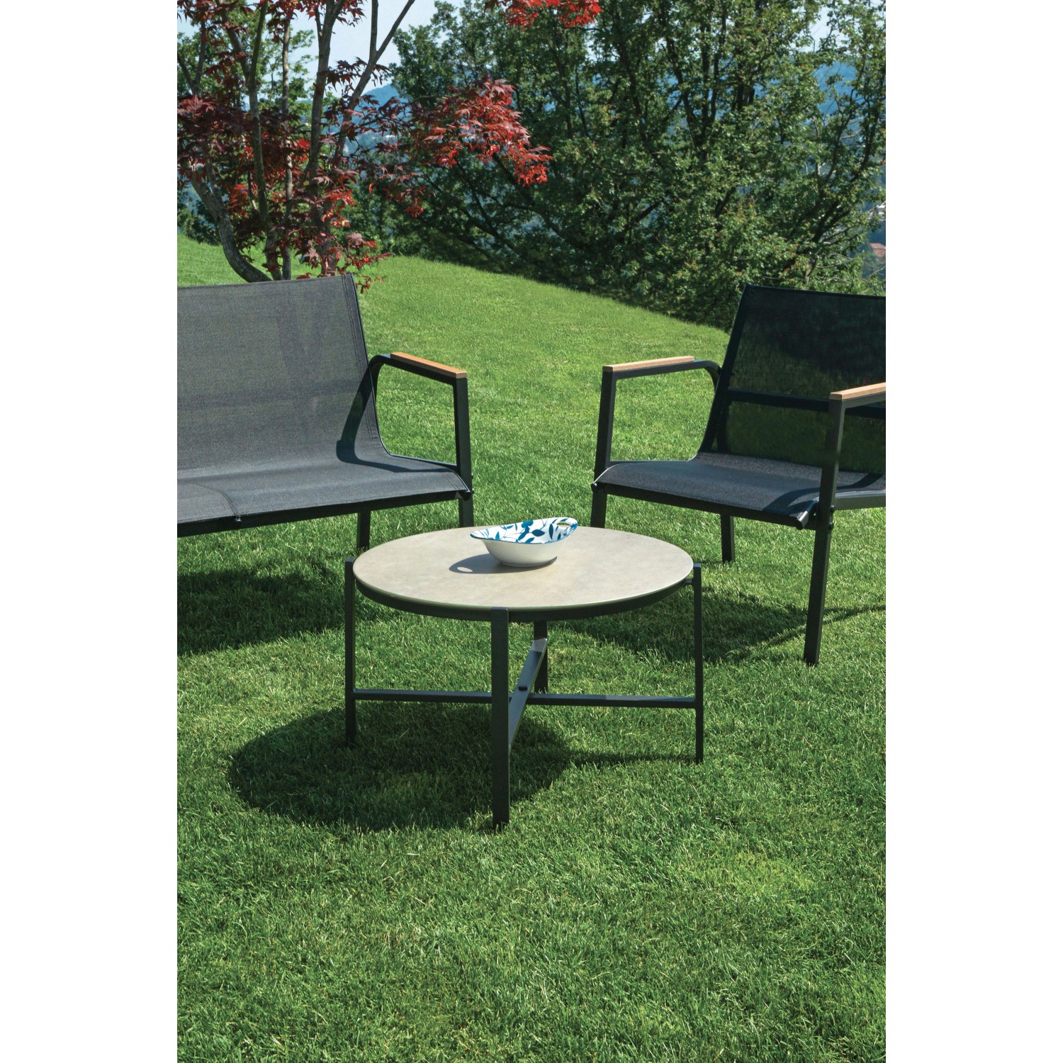 Set di mobili da giardino t.b.t. con tavolo e sedie su prato.