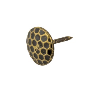 Primo piano di un singolo chiodo decorativo con motivo a nido d'ape nero su sfondo dorato.