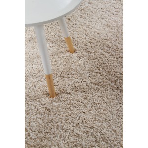 Tappeto a pelo lungo beige (t.b.t.) con gambe del tavolo nell'immagine.