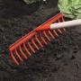 Rastrello da giardino con 14 denti e manico in legno in uso su un'aiuola con piante di lattuga.