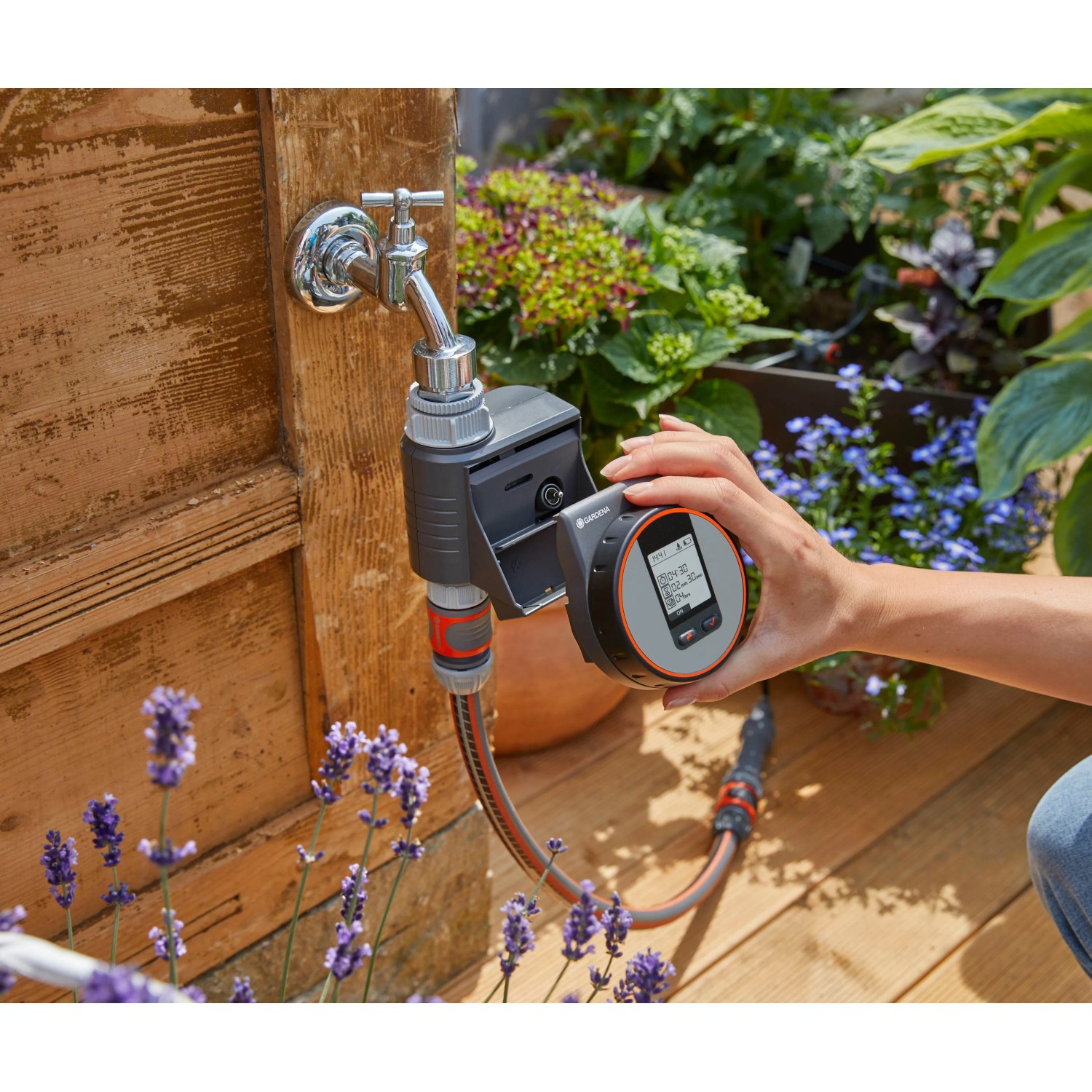 Computer per irrigazione Gardena Flex su rubinetto con display in mano.