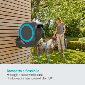 Gardena Avvolgitubo a muro RollUp S con tubo da 15 m in uso, donna che annaffia il giardino.