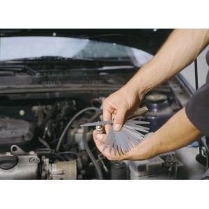 Calibro spessimetrico LUX Comfort con 20 lame che misura una candela nel vano motore.