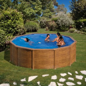 Piscina rotonda Gre Pacific effetto legno, Ø 240 cm, con famiglia in giardino.