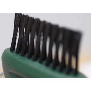 Primo piano di una piccola spazzola da giardino con setole verdi.