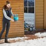 Donna sparge sale su superficie ghiacciata con spargitore manuale Gardena M.
