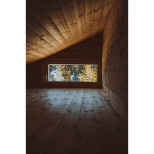 Stanza in legno con pavimento Listoni e vista finestra sugli alberi.