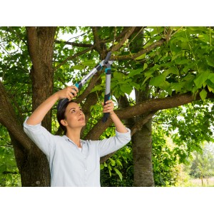 Donna che pota rami in giardino con la cesoia Gardena EasyCut 500 B.