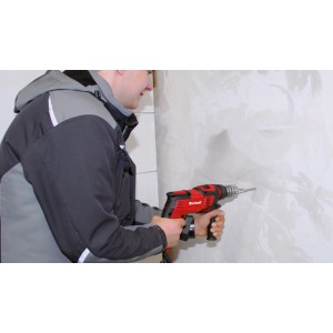 Trapano a percussione Einhell TC-ID 1000 E in uso durante la foratura di una parete.