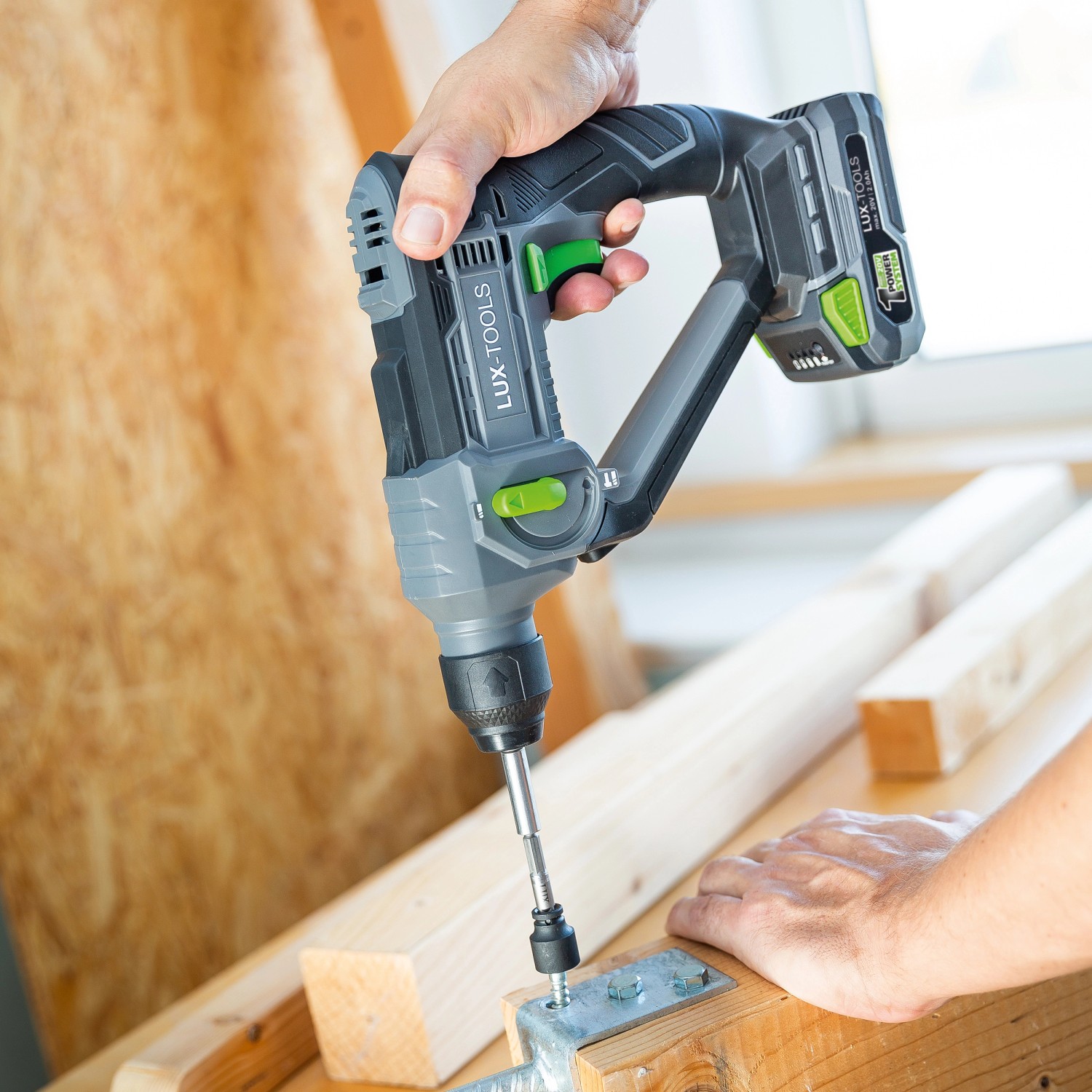 Trapano a percussione a batteria LUX A-BH-20 avvita nel legno. Il trapano è grigio e nero.