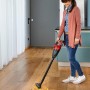 Donna aspira briciole sul parquet con l'aspirapolvere a batteria Einhell TE-VC 18 Li Solo.