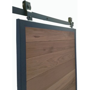 Dettaglio di una porta scorrevole con ferramenta. Legno e metallo in colore scuro.